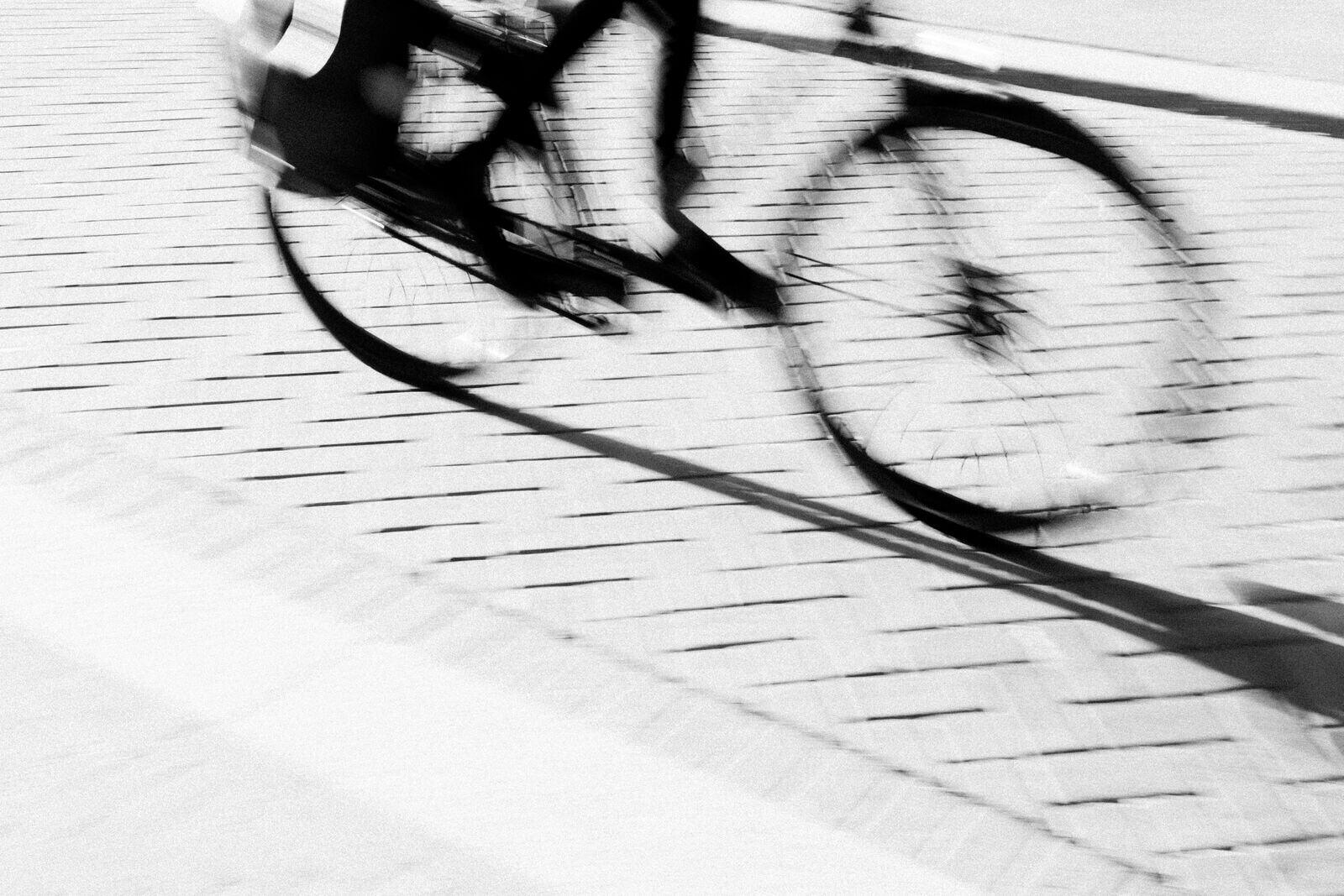 Rörelse i svartvitt — en cykel i fart över kullersten