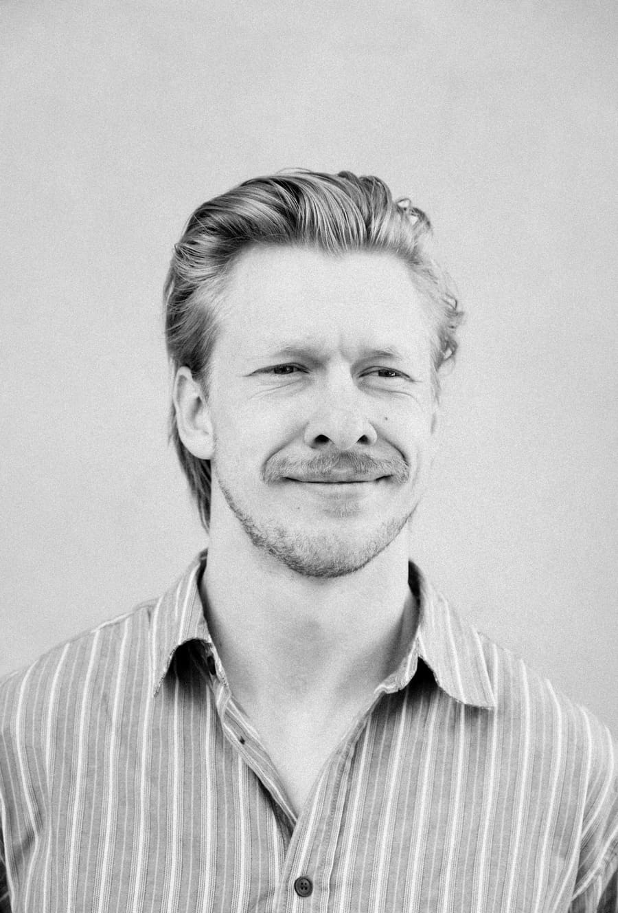 Studio headshot of a Light teammate with a mustache
