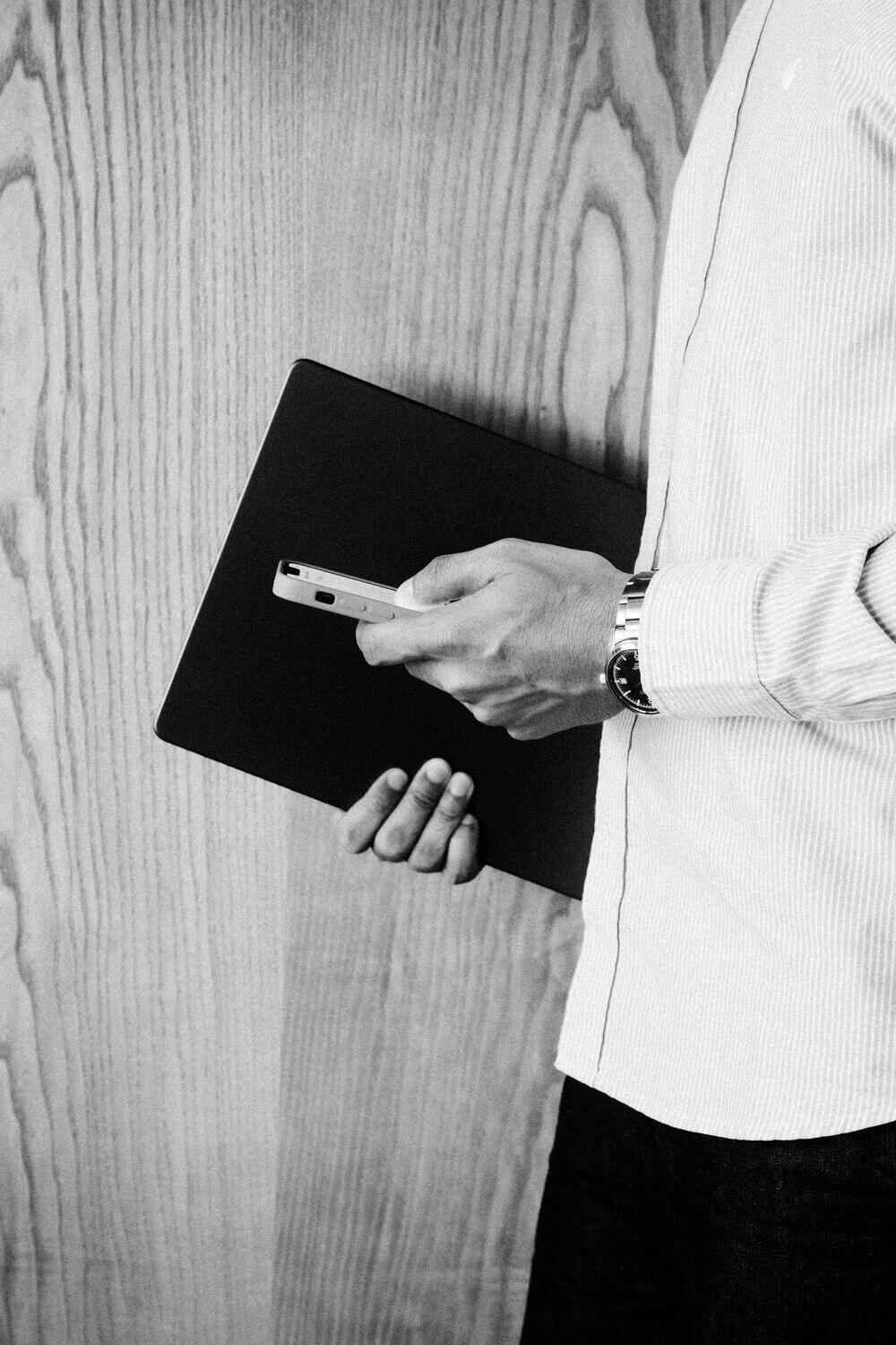 A person holding a laptop and a Light card