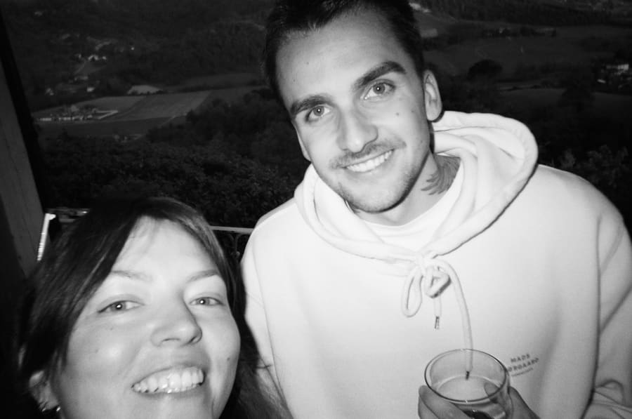 Two teammates smiling together with a countryside view behind them